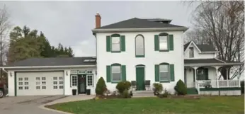  ?? CENTURY 21 LEADING EDGE REALTY INC. PHOTOS ?? The two-and-a-half-storey home stands out with a white clapboard-like façade and dark green California shutters.