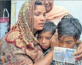  ?? SAMEER SEHGAL/HT ?? Seema grieves for husband Sonu Shira, with sons Karan (R) and Arjun, after receiving the news of his death in Iraq, at Chawinda Devi village near Amritsar on Tuesday.
