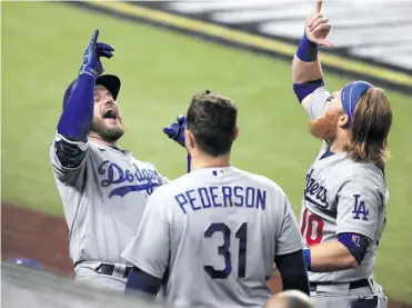  ?? EFE ?? Max Muncy de los Dodgers celebra con su compañero Justin Turner, mientras son observados por Joc Pederson.