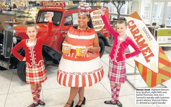  ??  ?? Sweet treat Highland dancers Amy Struthers, eight (left), and Rachel Thomson, nine, try a Tunnock’s teacake with customer service advisor, Shannon Paton, 21, dressed as a giant teacake
