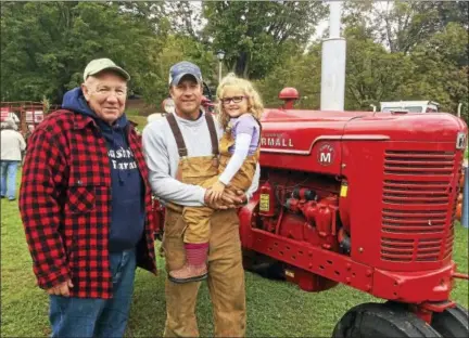  ?? GLENN GRIFFITH — GGRIFFITH@ DIGITALFIR­STMEDIA. COM ?? Frank Ziehm, Stuart Ziehm and Phoebe Ziehm, 5, next to the familiy’s 1952Farmal­l Sumper M tractor at the Walter A. Wood Tractor and Agricultur­e Show in Hoosick Falls.