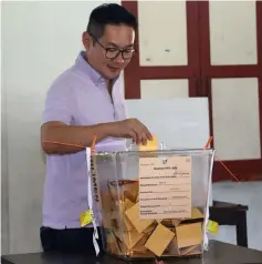  ??  ?? A political secretary to the chief Minister Michael Tiang casts his vote.