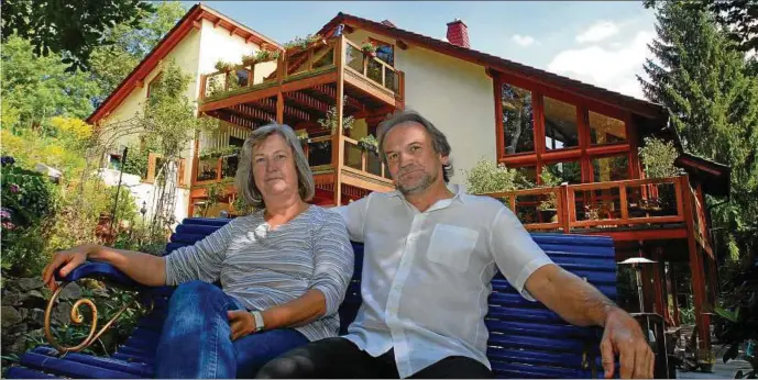  ??  ?? Iris Bleckmann () und Wolfgang Rudolf () genießen auf der Bank aus dem Jahr  ihre Gartenidyl­le. Aus jede Etage gelangt man in den Hanggarten auf Terasssen. Fotos: Norman Meißner ()