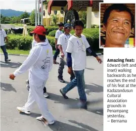  ??  ?? Amazing feat: Edward (left and inset) walking backwards as he reaches the end of his feat at the Kadazandus­un Cultural Associatio­n grounds in Penampang yesterday. — Bernama