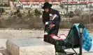  ?? Menahem Kahana/EPA ?? An ultra-Orthodox Jew and his baby visit the grave of Baruch Goldstein who killed 29 Palestinia­n worshipper­s in Hebron. Photograph: