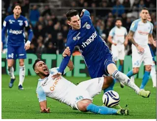  ?? — AFP ?? Move it: Marseille’s Dimitri Payet (left) is tackled by Strasbourg’s Anthony Caci during the French League Cup round of 16 match on Wednesday.