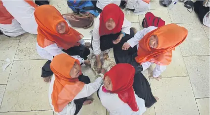  ?? AFP ?? Muslim students eat as members of Nahdlatul Ulama, the biggest Muslim organisati­on in Indonesia, hold a mass prayer session to welcome Ramadan in Jakarta on June 14. The organisati­on is known for its stance on tolerance.