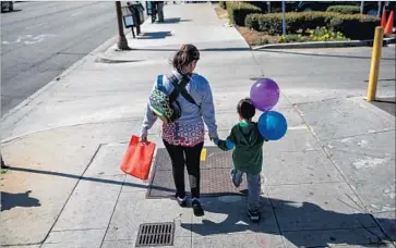  ?? Marcus Yam Los Angeles Times ?? A SALVADORAN immigrant in the U.S. illegally, Veronica Coban walks with her son, 5, and daughter, 1 (not visible in a carrier), after paying bills. “I haven’t been out in almost a week,” she said. “I’ve been afraid.”