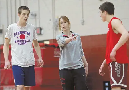  ?? STAFF PHOTO BY JOHN WILCOX ?? PRACTICE MAKES PANTHERS: Holliston coach Jenna Galster works with players Will Rowe, left, and Satchel Snow during a practice at the school on Wednesday.
