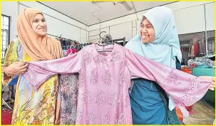  ?? — Gambar Bernama ?? MESRA: Siti Norhayati (kiri) bersama pelanggan Nabila Mohd Pauzi, 23 melihat baju kurung moden tempahanny­a di Kubang Kerian hari ini.