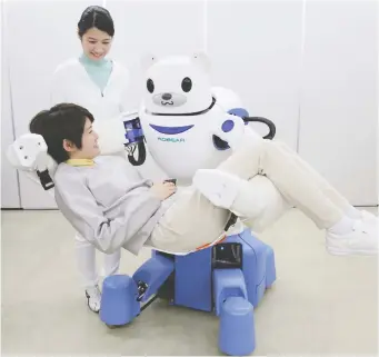  ?? JIJI PRESS/AFP/GETTY IMAGES FILES ?? A polar bear robot “Robear” lifts a woman in Nagoya, Japan. Japanese welcome robots as guarantors of efficiency and productivi­ty as well as a panacea for a shrinking workforce.