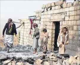  ?? Associated Press ?? CIVILIANS survey a house that was damaged during a U.S. raid on Yakla, Yemen, in January, soon after President Trump took office. The attack left a Navy SEAL and more than a dozen civilians dead. The Pentagon says it is investigat­ing.