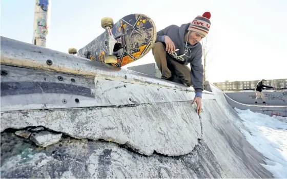  ?? CLIFFORD SKARSTEDT/EXAMINER ?? Chris Morton looks at cracks in the concrete at West 49 Skate Park. City council will receive a report Monday that looks at the future repair costs of the facility. Inadequate lighting is an issue too, skaters at the park say. Other items on council’s...