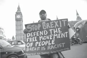  ??  ?? An anti-Brexit protester holds a sign outside the Houses of Parliament in London, Britain. — Reuters photo