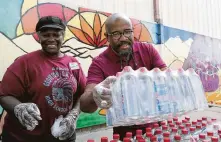  ?? Houston Chronicle file ?? Pastor Rudy Rasmus hands out packs of bottled water at St. John’s United Methodist Bread of Life facility.