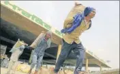  ?? PTI ?? Labourers load wheat sacks into a truck in Bathinda