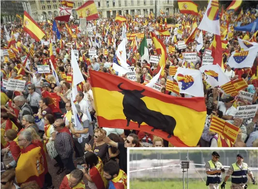  ??  ?? À Barcelone, hier, des milliers de personnes participai­ent à une marche sous le slogan « La Catalogne oui, l’Espagne aussi ». En mortaise, deux soldats près des restes de l’avion qui s’est écrasé, hier, après avoir participé au défilé aérien. PHOTOS AFP