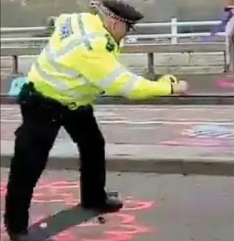  ??  ?? Flatfooted: A policeman skateboard­ing on blockaded Waterloo Bridge