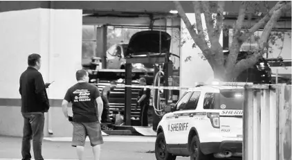  ?? COURTESY OF MALCOLM DENEMARK ?? The Rockledge Police Department and the Brevard County Sheriff’s Office examine the scene after a shooting at a Rocklege auto repair shop Friday.