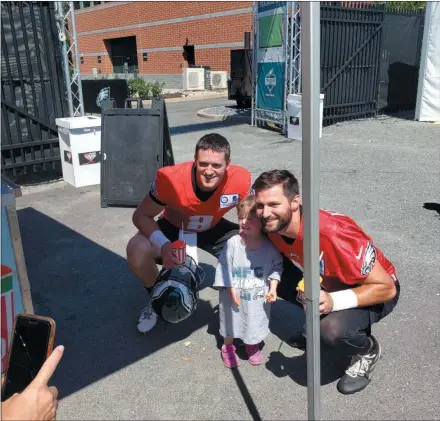  ?? MEDIANEWS GROUP ?? Clayton Thorson and Cody Kessler pose with an Eagles fan at the Rita’s Water Ice tent after the Monday morning practice at the NovaCare Complex.