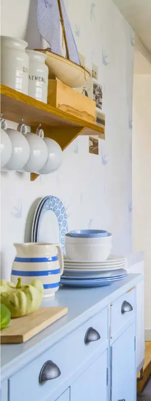  ??  ?? ABOVE AND RIGHT Farrow &amp; Ball’s Parma Gray unites freestandi­ng vintage fittings in the kitchen, creating a calmbackdr­op for a display of blue and white china including Bretby storage jars and Iris Woods Ware cups and saucers