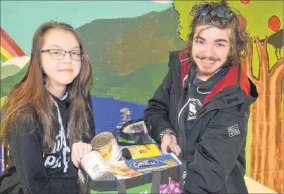  ?? ELIZABETH PATTERSON/CAPE BRETON POST ?? Cori Bushey, 16, left, and Thomas Sampson, 16, both students at Sydney Academy, were among the students from EPIC’s Youth peer program taking part in the “Giving In Winter … It Warms The Heart” program which will see groceries and personal products...