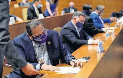  ?? POOL VIA REUTERS ?? Stephen Roe Lewis, a member of Arizona's Electoral College, signs his name to the Arizona presidenti­al electoral ballot in Phoenix on Monday.