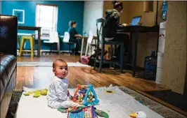  ??  ?? Zachary Vizcaino plays on a mat while his mother, Emily (right), works nearby at Play, Work or Dash. Just 7 percent of traditiona­l employers provide child care at or near the workplace, and 5 percent offer backup care when child-care arrangemen­ts fall...