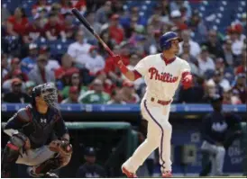  ?? MATT SLOCUM — THE ASSOCIATED PRESS ?? Philadelph­ia Phillies’ Cesar Hernandez, right, follows through after hitting a two-run home run off Atlanta Braves relief pitcher Arodys Vizcaino during the eighth inning of a baseball game, Sunday in Philadelph­ia. Braves catcher Kurt Suzuki, left,...