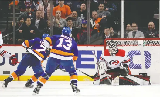  ?? JULIO CORTEZ/AP ?? Islanders winger Jordan Eberle fires a shot off the crossbar behind Hurricanes goalie Curtis McElhinney late in Carolina’s 2-1 win in Game 2 of their series.