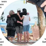  ??  ?? Kerry and Lynne Martin and a friend comfort each other on the beach.