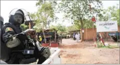  ?? HABIBOU KOUYATE/AFP ?? A soldier looks on as investigat­ors walk at the entrance of the Kangaba tourist resort in Bamako yesterday.