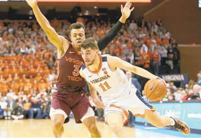  ?? RYAN M. KELLY/GETTY IMAGES ?? The Virginia Cavaliers' Ty Jerome drives past Virginia Tech's Wabissa Bede during U.Va.'s triumph at John Paul Jones Arena on Tuesday.