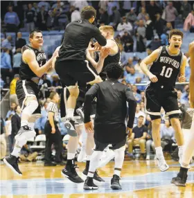  ?? Ellen Ozier / Associated Press ?? Wofford players including Fletcher Magee (far left) and Nathan Hoover (10) celebrate after the Terriers beat fifth-ranked North Carolina 79-75.