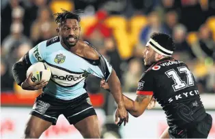  ?? PHOTO: GETTY IMAGES ?? Hanging by a thread . . . Warriors hooker Jazz Tevaga (right) grabs at the jersey of Sharks opposite number James Segeyaro in their NRL match in Auckland last night.