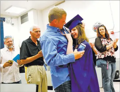  ?? Rachel Aston ?? Las Vegas Review-journal @rookie__rae Sydney Goecke hugs her father, Jason Goecke, on her way down the aisle at Helen J. Stewart School on Wednesday. The special needs school hosted a graduation ceremony for its students.