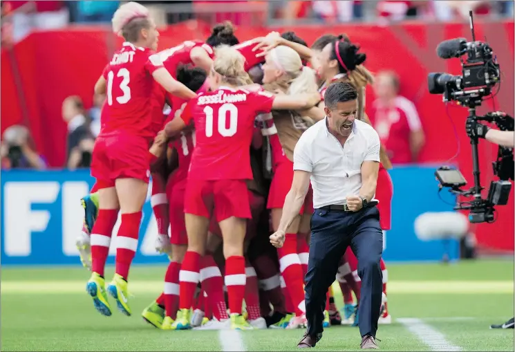  ?? — THE CANADIAN PRESS FILES ?? Team Canada head coach John Herdman, right, celebrates as Josée Bélanger, back, is mobbed by teammates after scoring against Switzerlan­d in the FIFA Women’s World Cup round of 16 game in Vancouver on Sunday. Herdman has led the team to a pair of 1-0...