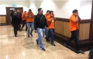  ??  ?? The policemen escorted by MACC personnel to the magistrate’s chambers yesterday.