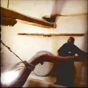  ??  ?? A Coptic priest holds an ancient key and shows how to operate an ancient grain mill.