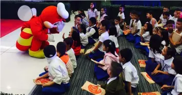  ??  ?? Jollibee gives a high five to students of Telabastag­an Intergrate­d School