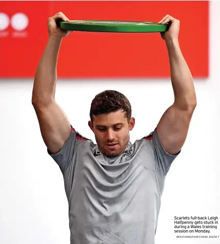  ?? BEN EVANS/HUW EVANS AGENCY ?? Scarlets full-back Leigh Halfpenny gets stuck in during a Wales training session on Monday.