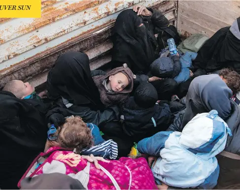  ?? FADEL SENNA / AFP / GETTY IMAGES ?? Women and children fleeing from the last Islamic State group’s tiny pocket in Syria sit in the back of a truck near Baghuz, eastern Syria, on Monday, as the U.S.-backed Syrian Democratic Forces fighters pushed to retake a last territory from ISIL fighters, many of them foreigners.