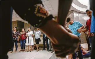  ?? Melissa Phillip / Houston Chronicle ?? Relatives of the late John Hernandez and their supporters pray in the hall outside the court where Terry Thompson, accused of fatally choking Hernandez, was on trial Thursday.