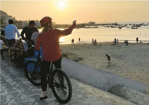  ?? COLLEEN THOMAS/TNS PHOTOS ?? Cyclists on a bike tour stop to gaze at the view along the oceanfront in Lima, Peru.