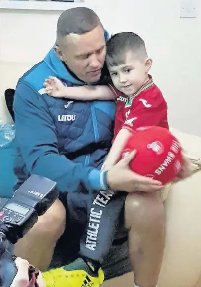  ?? KIRSTIE SMITH ?? Swansea City legend Lee Trundle surprised six-year-old Harvey Doak with a visit on his birthday