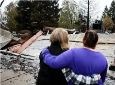  ??  ?? Irma Corona (right) comforts neighbour Gerryann Wulbern in front of the remains of Wulbern’s home after the two returned for the first time since the Camp Fire in Paradise. — Reuters photo