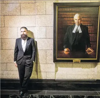  ?? DARREN BROWN ?? Paul Wyse, an Osgoode artist who was commission­ed to paint a portrait of former prime minister Paul Martin, stands beside his portrait of former Speaker Peter Milliken in Centre Block on Tuesday.