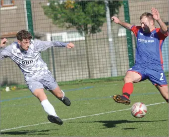  ??  ?? Brian McCloskey of Bay attempts to block a shot at goal by Boyne Harps striker Stephen Carter during Sunday’s Challenge Cup match at Muirhevnam­or.