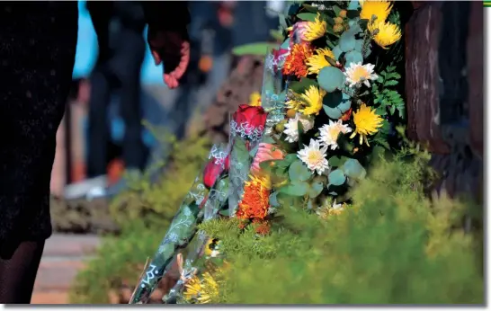  ??  ?? A relative walks away after leaving a rose commemorat­ing a loved one in front of the SANDF’s brand new memorial wall at the De Brug Mobilisati­on Centre outside Bloemfonte­in on Tuesday May 29, 2018.