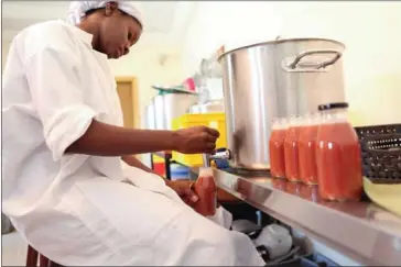  ?? AFP ?? An employee of Zabbaan Holding, fills a bottle of juice made in Bamako, Mali, on October 13.